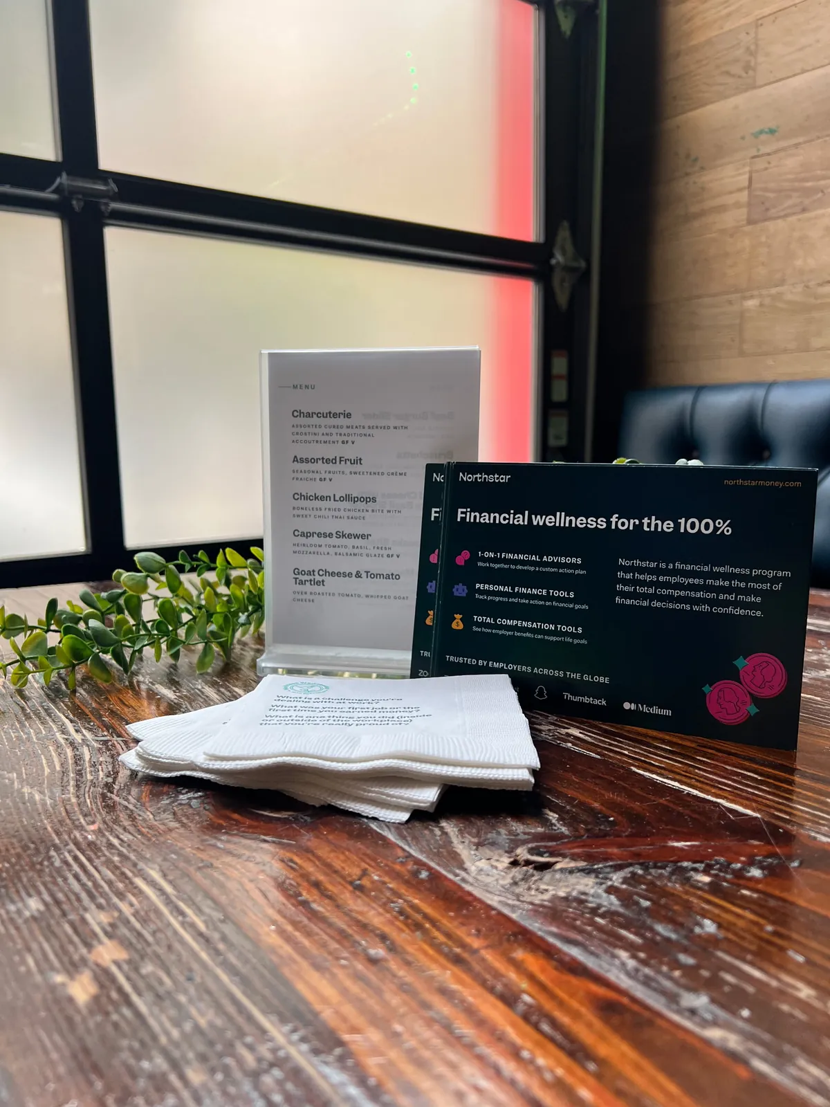 This is an example of a custom small-bites menu, a postcard, and conversation-starter napkins planned for a happy hour.